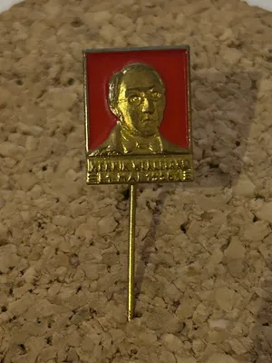 Gullfarget 1. mai-merke fra 1958 med opphøyd portrett av Henrik Wergeland mot rød bakgrunn.